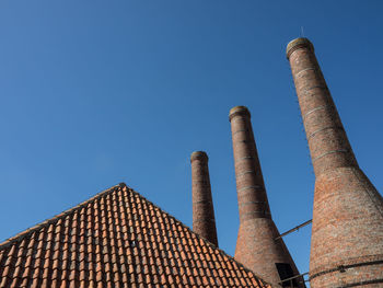 Low angle view of smoke stack against sky