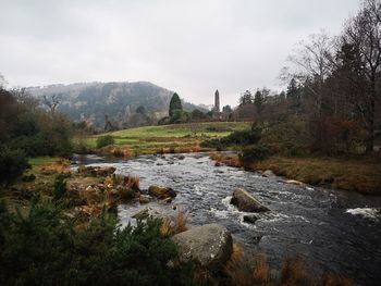 Scenic view of river amidst trees against sky