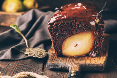 Homemade chocolate cake with pear at rustic wooden background. brownie with fudge. selective focus.