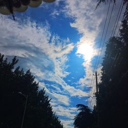 Low angle view of power lines against cloudy sky