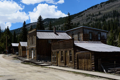 House amidst trees and buildings against sky