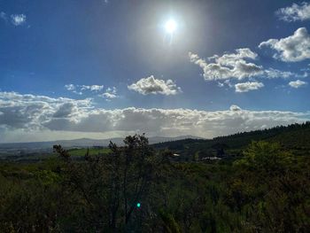 Scenic view of landscape against bright sun