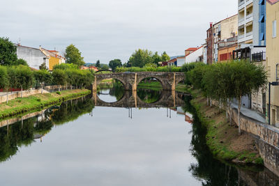 Arch bridge over river against sky