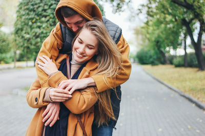 Couple wearing warm clothing while standing on footpath at park