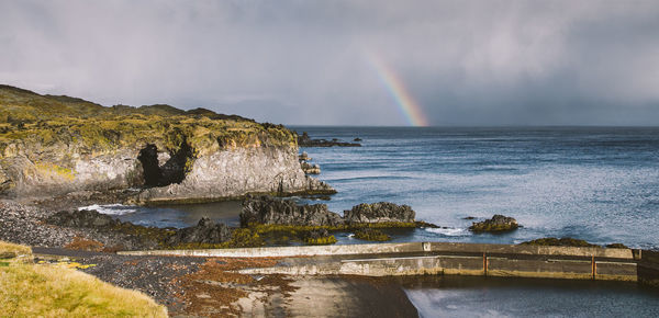 Scenic view of rainbow over sea against sky