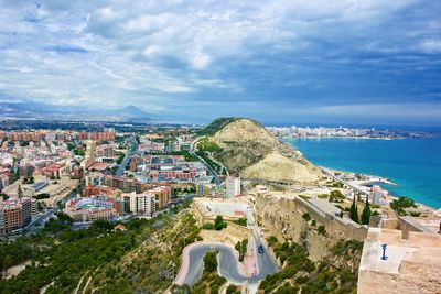 High angle view of townscape by sea against sky