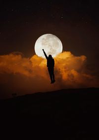 Silhouette man against moon at sunset