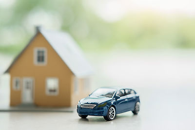 Close-up of toy car and model house on table