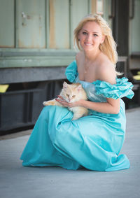 Close-up portrait of woman with dog crouching at railroad station platform