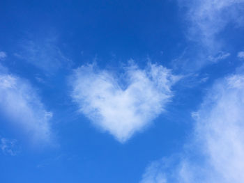 Low angle view of heart shape against blue sky