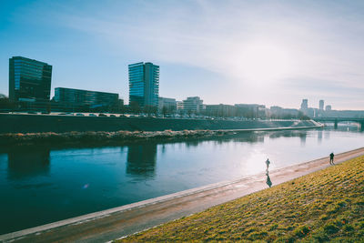 Scenic view of river by buildings against sky