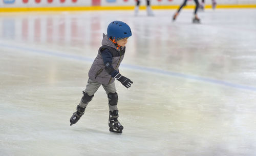 Full length of boy skating on ice rink