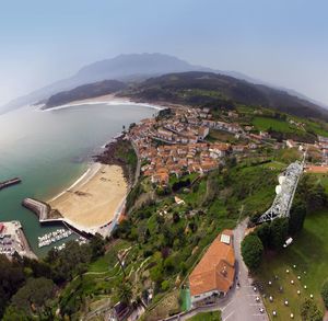 High angle view of townscape by sea against sky