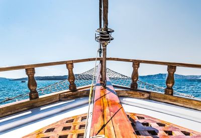 Close-up of sailboat sailing on sea against clear sky