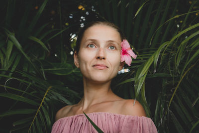 Smiling woman looking away by plants