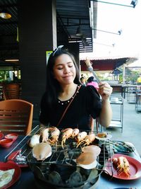 Young woman holding food while standing outdoors