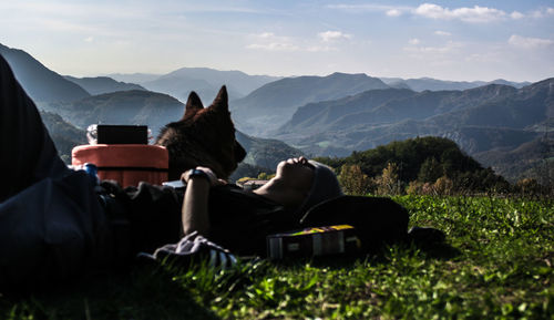 Man using mobile phone while sitting on mountain road