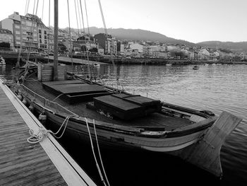 Boats moored on river in city against sky