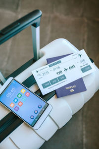 Top view of suitcase with air ticket, passport and cell phone