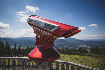 Close-up of red telescope against sky