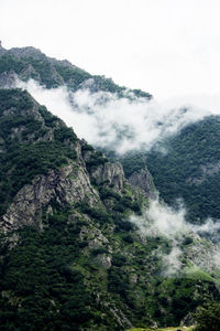 Scenic view of mountains against sky with fog