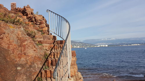 Suspension bridge over sea against sky