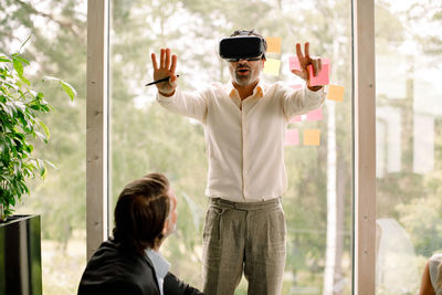 Businessman gesturing while wearing virtual reality simulator during conference at convention center