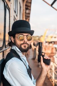 Portrait of man holding hat