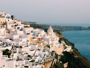 High angle view of cityscape by sea against clear sky