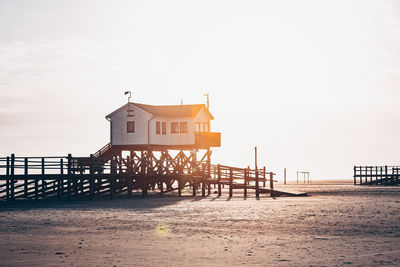 House on beach by sea against clear sky