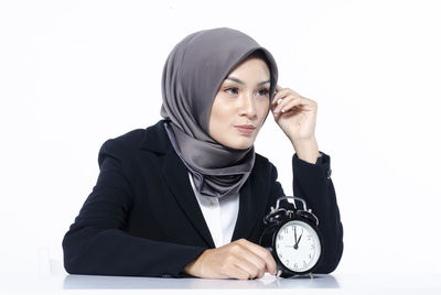 Portrait of young woman against white background