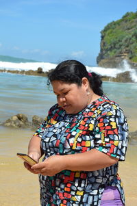 Side view of woman sitting on rock