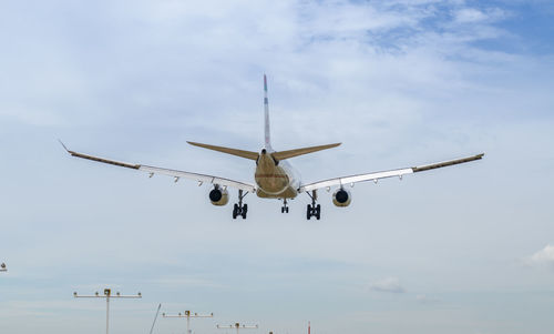 Low angle view of airplane flying against sky