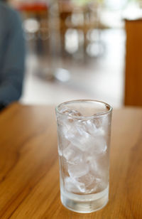 Close-up of ice cubes in drinking glass on table