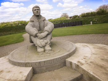 Statue in park against sky