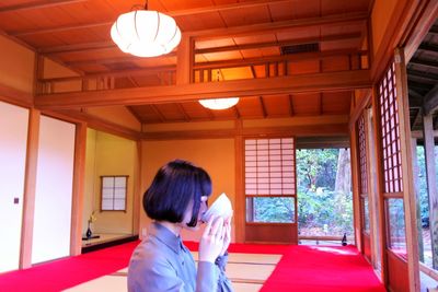 Side view of woman eating food indoors