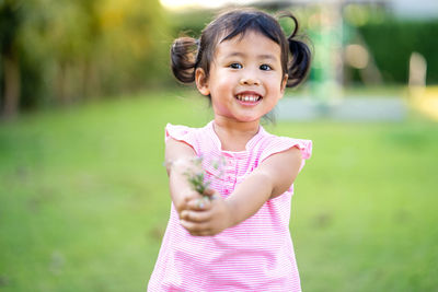 Portrait of smiling girl holding flowers