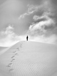 Silhouette of woman against cloudy sky