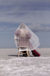 Rear view of man on beach against sky