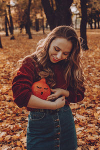 Happy young woman standing on land during autumn