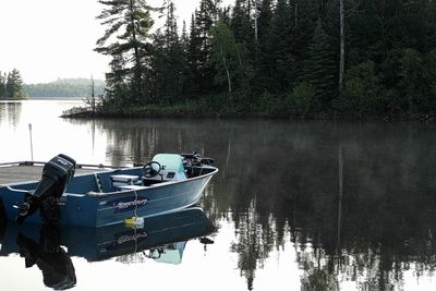 Boat in lake by trees