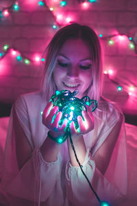 Close-up of young woman with christmas lights