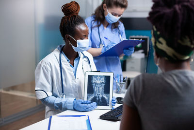 Midsection of doctor examining patient in office