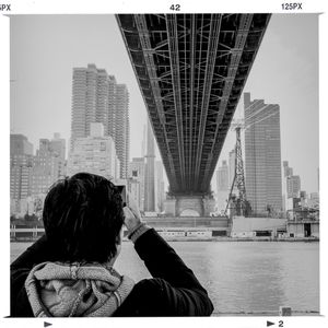 Woman standing on bridge in city