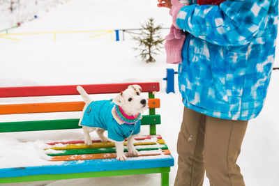 Man with dog standing against blue wall