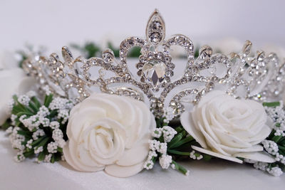 Close-up of artificial roses and tiara against gray background