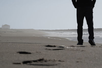 Solitude by the sea. low angle view silhouette of boy walking along the beach