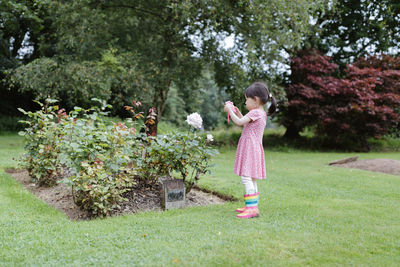 Young girl taking photo in the summer garden morning