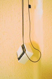 Close-up of electric lamp against wall