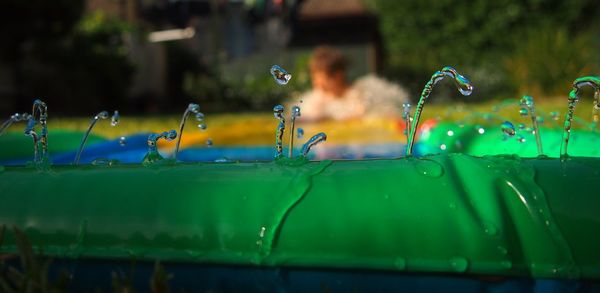 Close-up of water drops on wading pool in yard